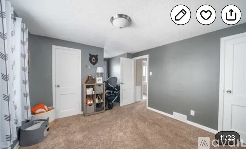 A room with a grey carpet and a white door.