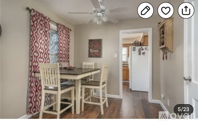 A dining room with a table and chairs.