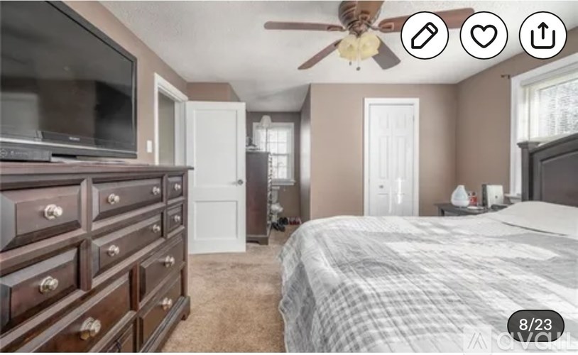A bedroom with a bed, dresser, and television.