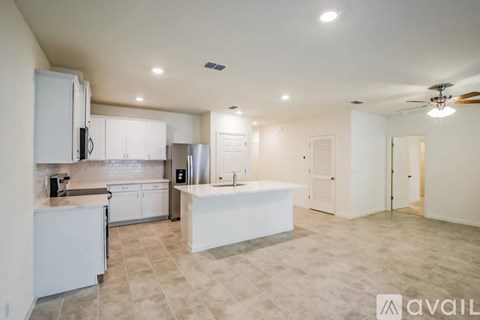 A spacious kitchen with white cabinets and a central island.