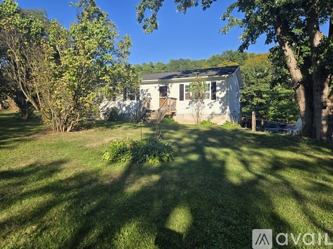 A white house with a tree in front of it.