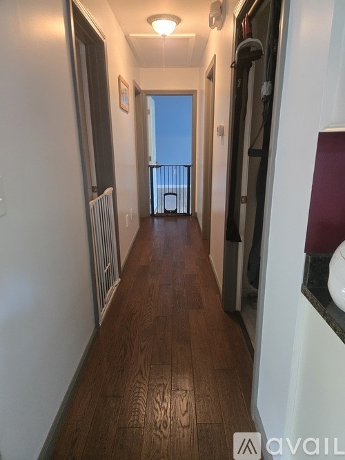 A long hallway with a balcony and a radiator on the wall.