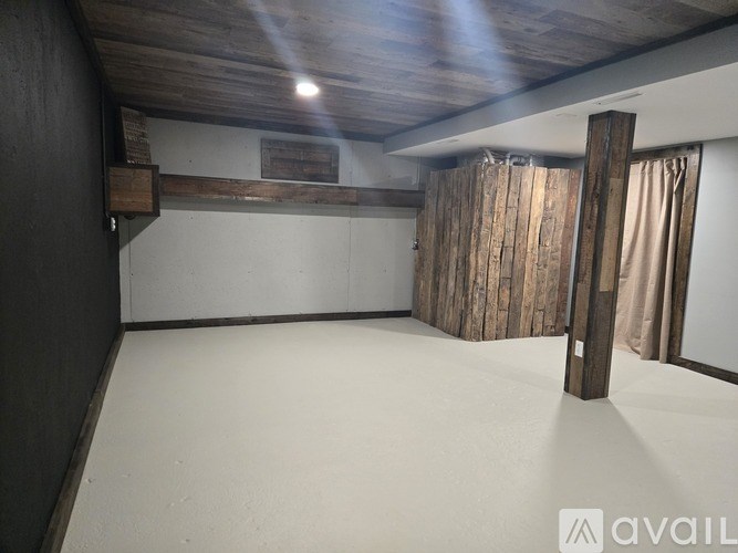 A room with wooden beams on the ceiling and a white floor.