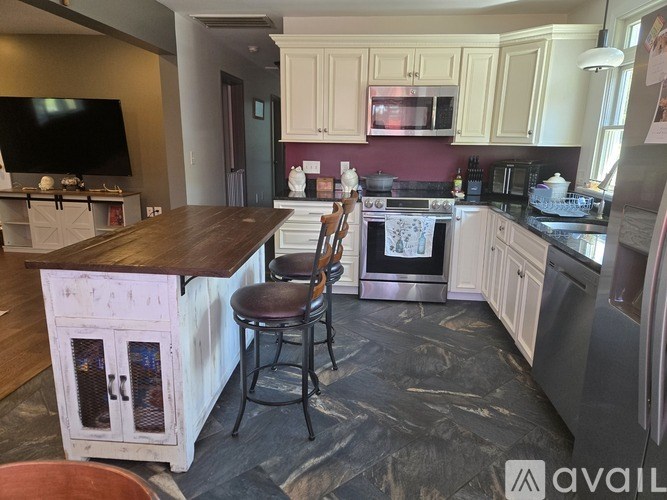 A kitchen with a wooden island and stools.