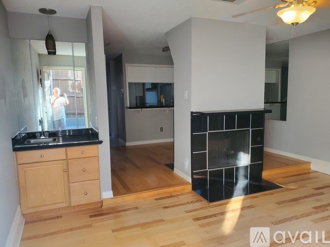 A kitchen with wooden floors and a black countertop.