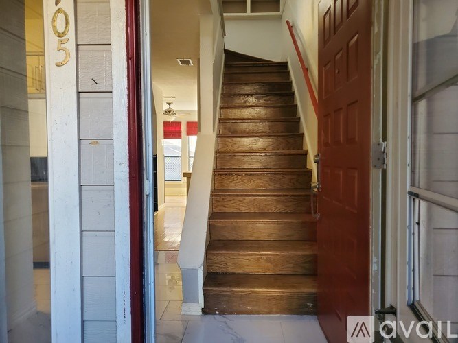 A staircase with a red door at the bottom.