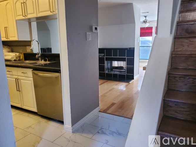 A kitchen with white cabinets and a black countertop.