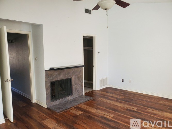 A room with a fireplace and a ceiling fan.