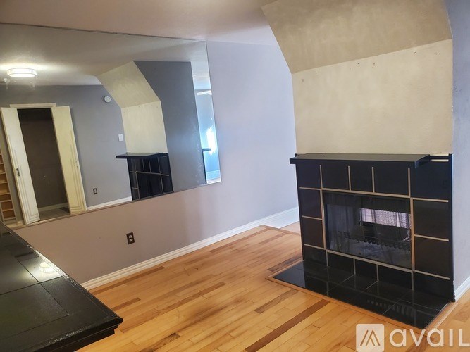 A room with a fireplace and wooden floors.