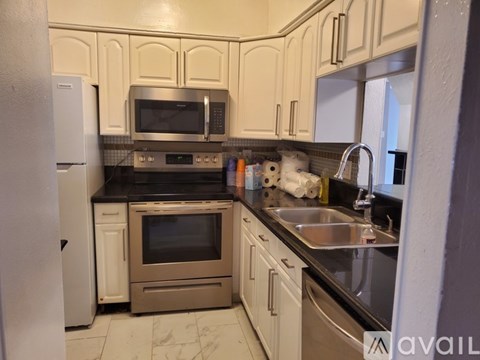 A kitchen with white cabinets and stainless steel appliances.