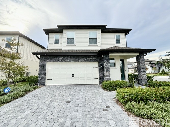 A modern house with a garage door and a driveway.