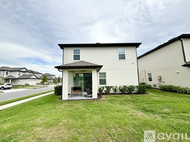 A house with a front yard and a car parked in the driveway.