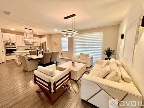 A modern living room with a white sofa and wooden flooring.