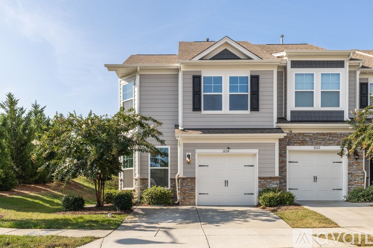 A two-story house with a garage and a driveway.
