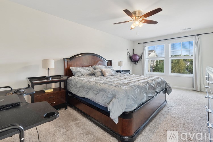 A bedroom with a large bed and a ceiling fan.