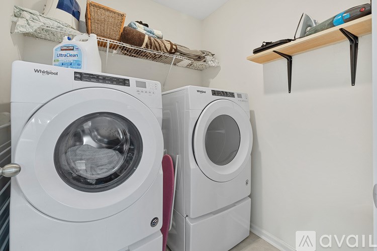 A white Whirlpool washing machine is in a small laundry room.