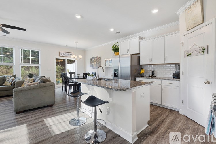 A kitchen with white cabinets and a marble backsplash.