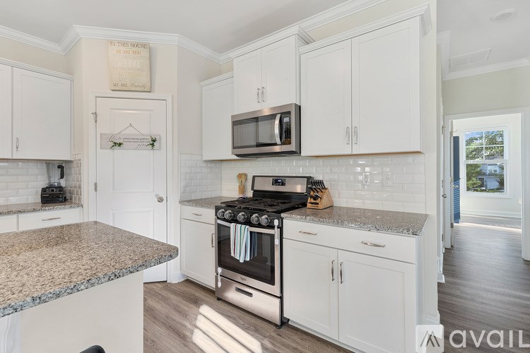 A kitchen with white cabinets and a granite countertop.