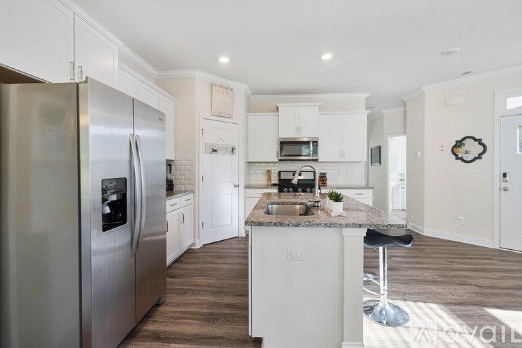 A modern kitchen with a large island and stainless steel appliances.