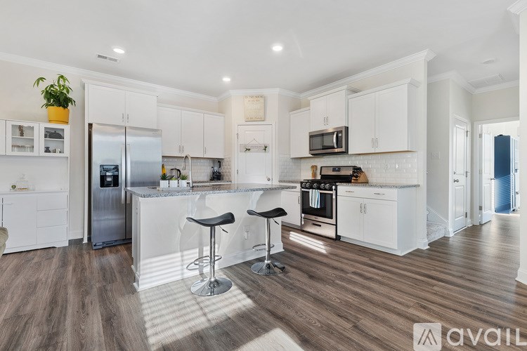 A kitchen with white cabinets and a wooden floor.