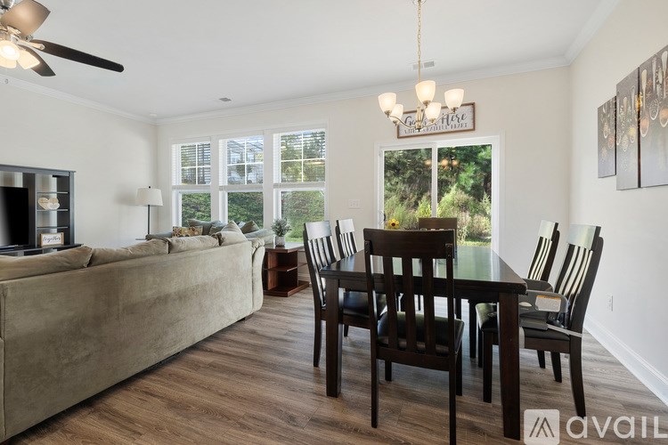 A living room with a couch, chairs, and a dining table.