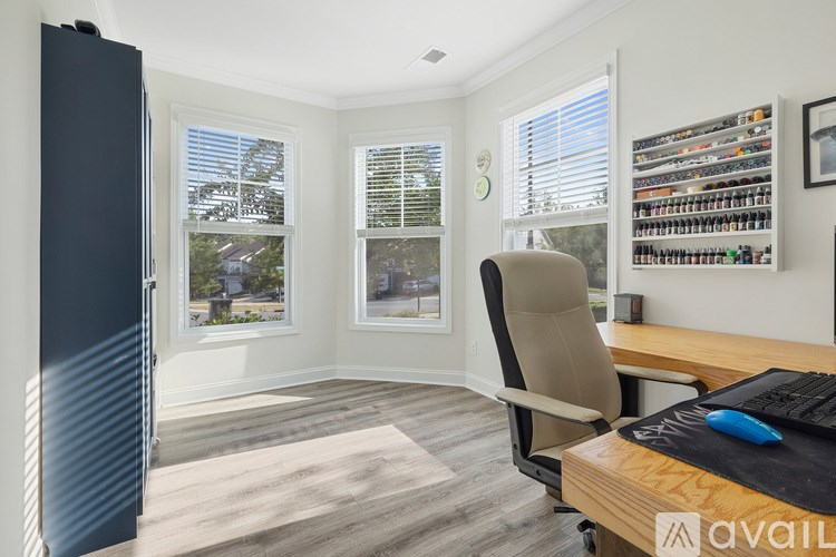 A room with a desk, chair, and shelves with various items.
