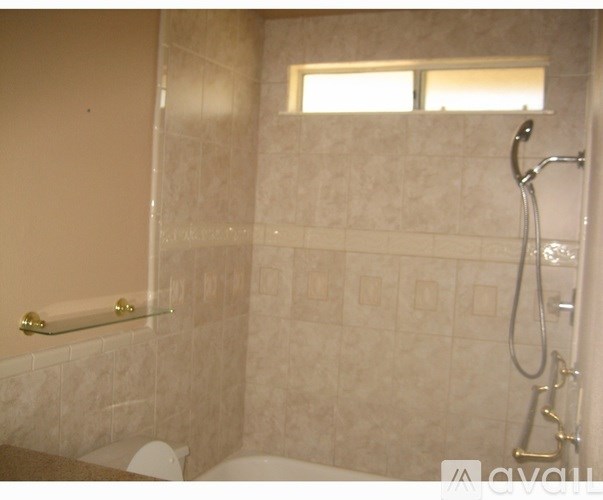 A bathroom with a shower and a toilet.