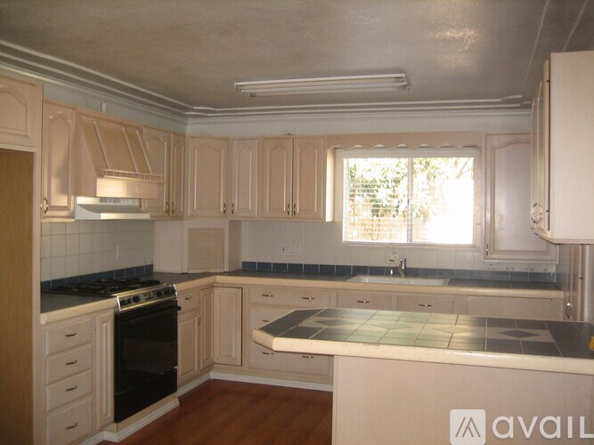 A kitchen with wooden cabinets and a black stove top oven.
