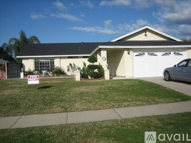 A house with a for sale sign in front of it.