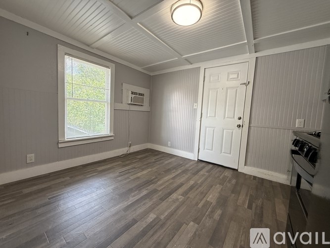 A room with a window and a door is available for rent.