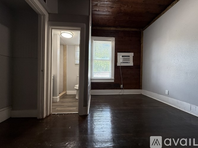 A room with a window and a wooden ceiling.