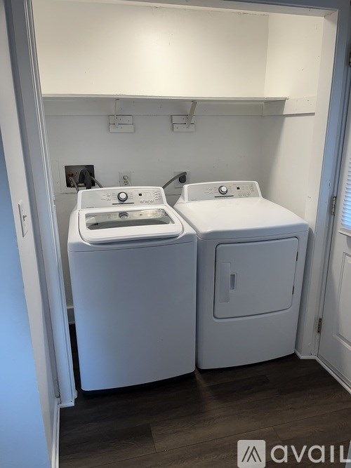 Two white washing machines in a small room.