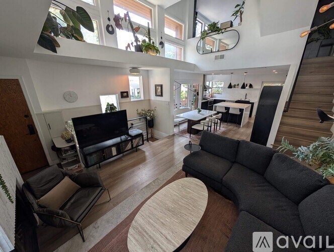 A living room with a black sofa and a television.