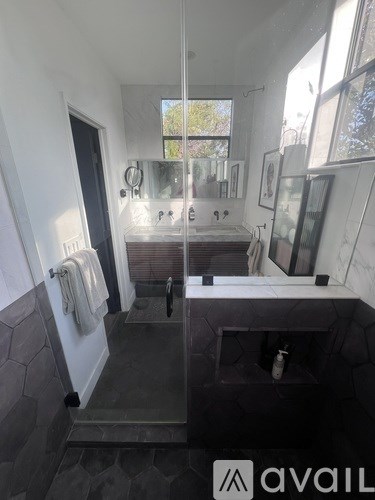 A bathroom with a walk-in shower and a large mirror.