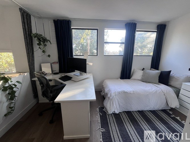 A bedroom with a bed, desk, and chair.