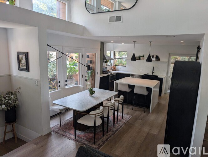 A modern kitchen with a dining table and chairs.