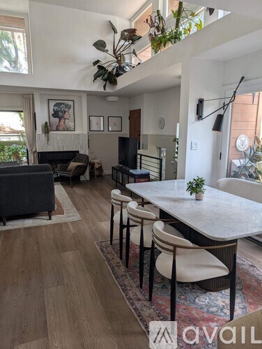 A living room with a grey couch, a white table, and a wooden floor.