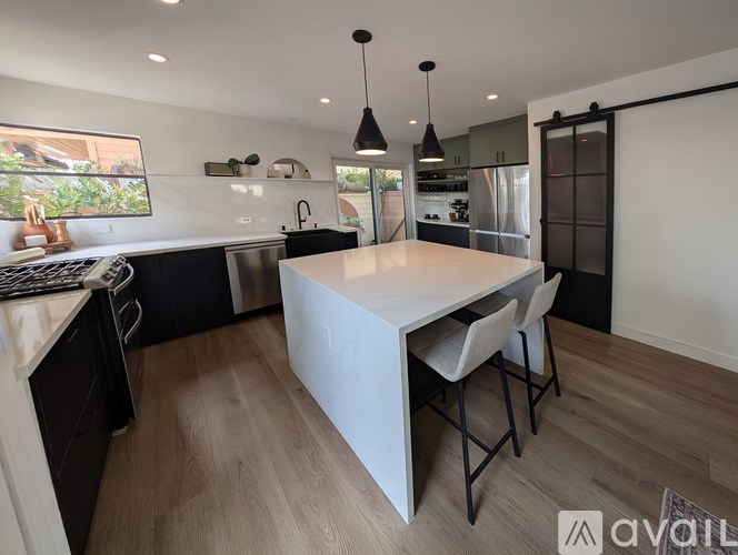 A modern kitchen with a large island and bar stools.