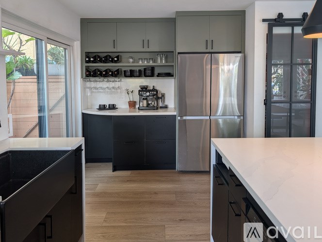 A modern kitchen with a refrigerator, cabinets, and a countertop.