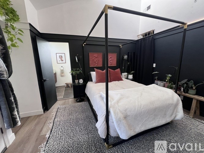 A bedroom with a four poster bed and a white bedspread.