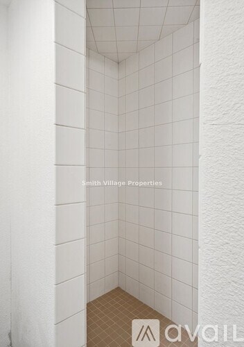 A white tiled bathroom with a white ceiling.