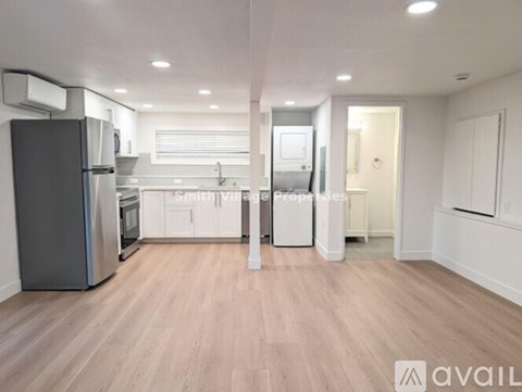 A kitchen with a refrigerator, sink, and cabinets.