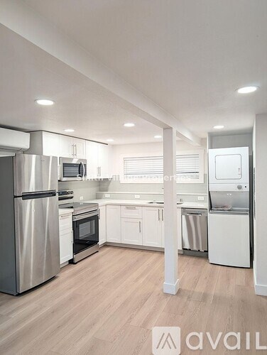 A modern kitchen with stainless steel appliances and white cabinetry.