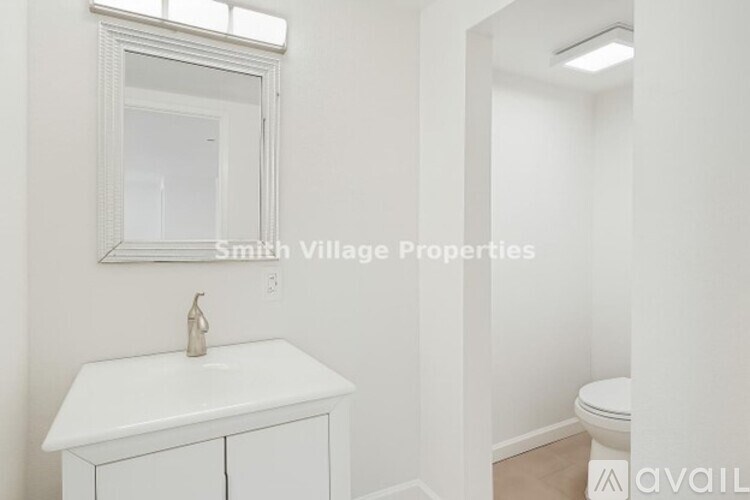 A bathroom with a sink, mirror, and toilet.