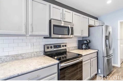A kitchen with a stove, oven, microwave, and refrigerator.