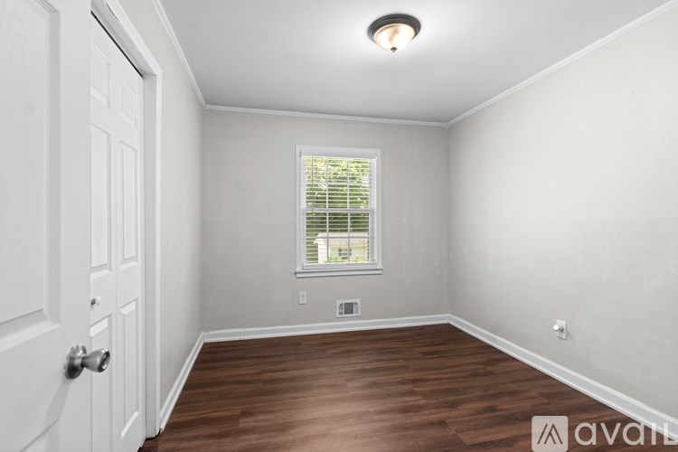 A room with a white door and a window with blinds.