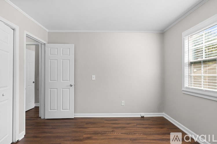 A room with a white door and a window with blinds.