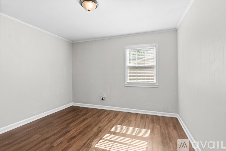 A room with a window and wooden flooring.
