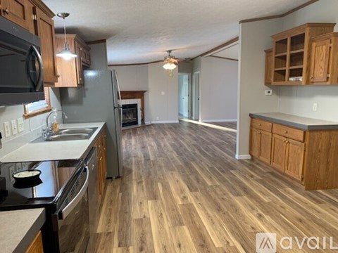 A kitchen with wooden floors and a black stove top oven.