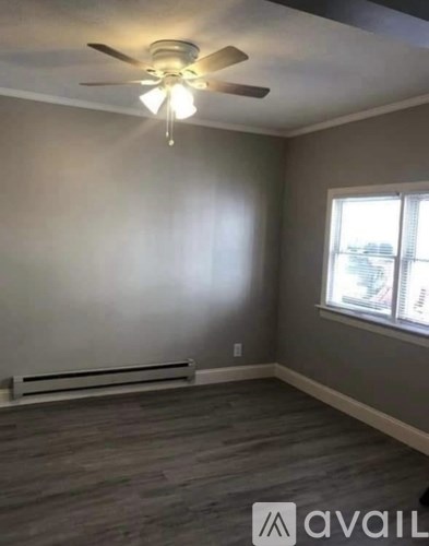 A room with a ceiling fan and a window.